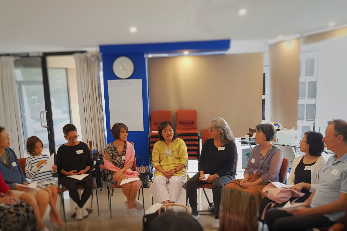 feature image_teach Buddhism to children People sitting on chairs arranged in a semi circle discussing teacher training
