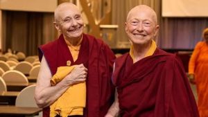 Two Buddhist monastic women at a conference posing for a photo.