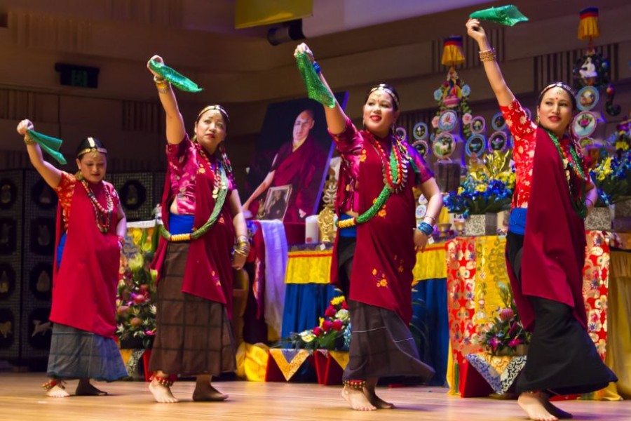 four nepalese dancers standing in a row on stage